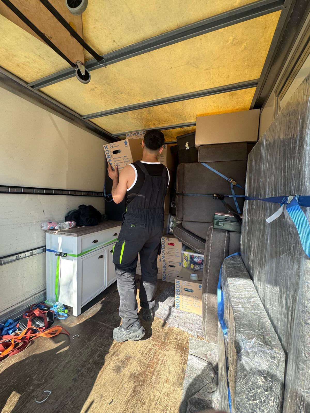 Erfahrene Umzugshelfer beim sorgfältigen Möbeltransport